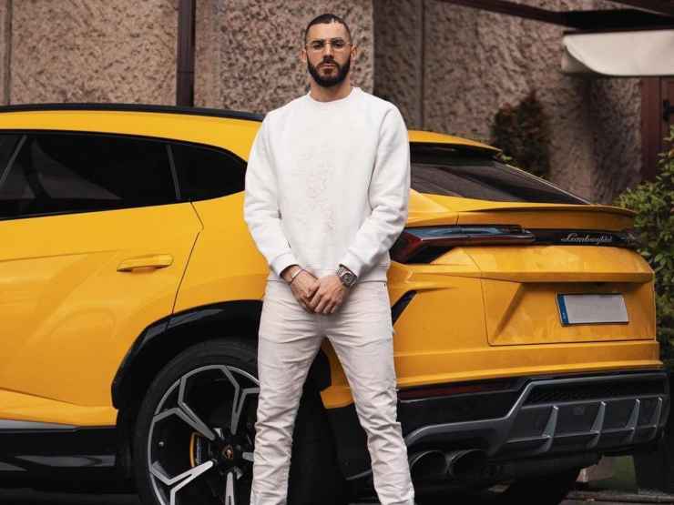 Karim Benzema in piedi accanto al suo Suv Lamborghini Urus giallo