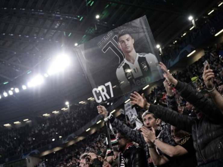 Tifosi juventini allo stadio con un poster di Ronaldo 